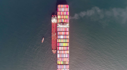 Top view of a large loaded container ship and a tanker standing side by side.