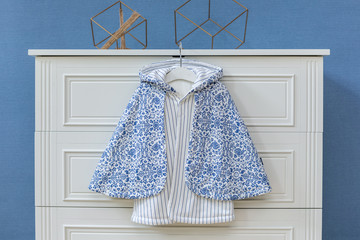 Baby clothes hanging on rope on grey background