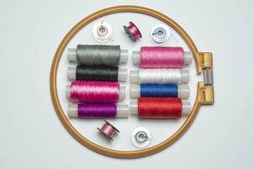 Set of multicolor spool threads and embroidery frame