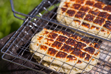Top view on two grilled slices of homemade halloumi cheese on grill. Outdoors..Grilling season.