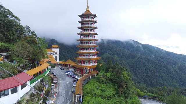 Aerial shot flying past cable cars towards beautiful popular tourist attraction Chin Swee Caves Buddha Temple at Genting Highlands in Pahang, Malaysia on August 7, 2017