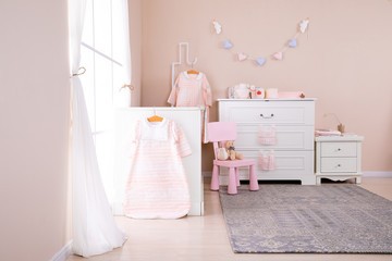 Simple, white baby bedroom with cot and rug