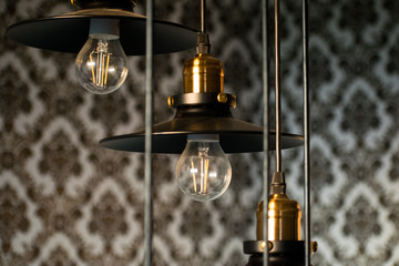 Fototapeta na wymiar Black decorative lamps hangs from the ceiling. Modern hanging lamps, modern interior design.