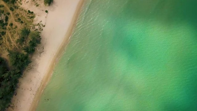 Crystal clear sea water and sandy shore on paradise beach aerial landscape. Top view turquoise ocean and sandy coast. Sea landscape drone view.