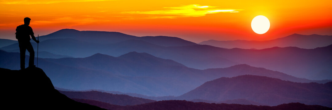 silhouette Of Hiker Watching Sunset Over Mountains - Powered by Adobe