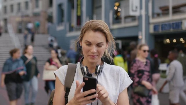 portrait of independent blonde woman tourist using smartphone app browsing texting enjoying city travel smiling optimistic