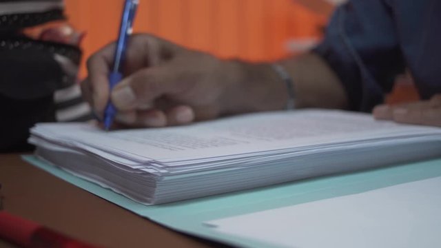 A teacher correcting an essay, with sheets as foreground focus