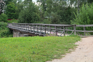 Old wooden bridge over river in summer countryside