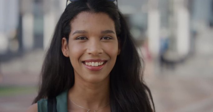 close up portrait beautiful young mixed race woman smiling happy in city slow motion