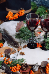 Mulled wine in glasses ,red berries,bumps and autumn branches on wooden table. Autumn or Winter concept.
