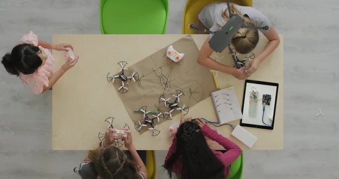 young group of multi ethnic student girls building drones together smart intelligent children design uav technology little girl flying drone in classroom top view