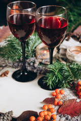 Mulled wine in glasses ,red berries,bumps and autumn branches on wooden table. Autumn or Winter concept.