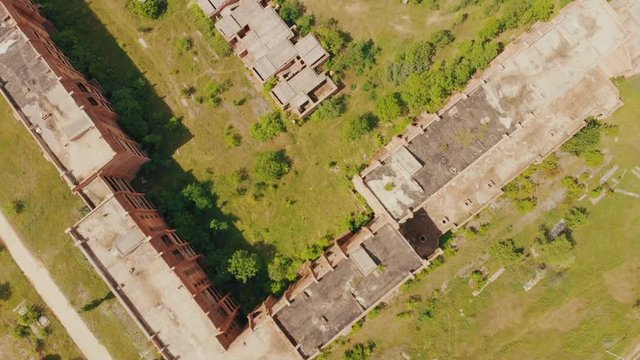 Flying above old abandoned construction. AERIAL: Flight over unfinished high-rise building with apartments. Drone view. Summer season. Abandoned city after disaster. HD footage.