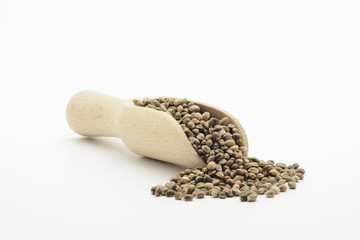 Semilla de cañamo en una cuchara de madera sobre fondo blanco