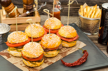 Homemade delicious mini hamburgers served with sauce and french fries. Homemade mini burgers.