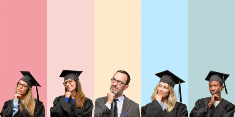 Obraz premium Senior teacher with his graduate students thinking and looking up expressing doubt and wonder