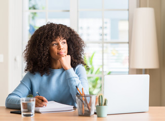 African american woman studying at home using a computer laptop serious face thinking about...