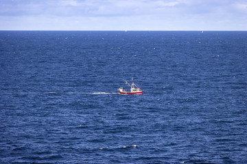 A small fishing boat rides rough on the North Atlantic