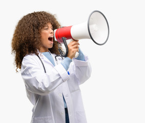 African american doctor woman, medical professional working communicates shouting loud holding a...