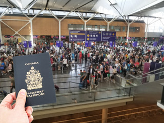 Hand handing Canadian passport at airport custom counters, immigration concept