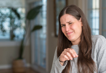 Young beautiful woman at home disgusted expression, displeased and fearful doing disgust face because aversion reaction. With hands raised. Annoying concept.