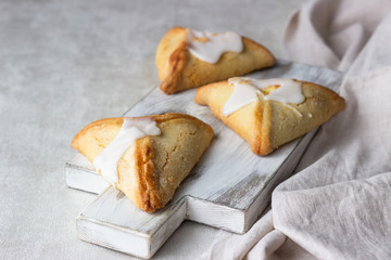 Pasties or buns with cottage cheese and powdered sugar glaze on a light background. Traditional Russian bun Sochnik. Selective focus. 