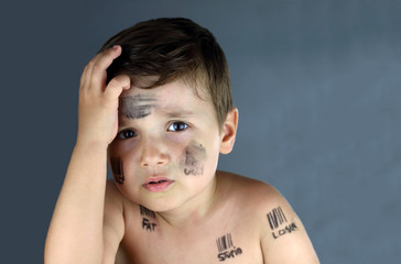 sad child who suffer bullying with bar code and insults in his face erasing some words in a grey...