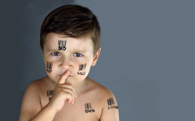 sad child who suffer bullying with bar code and insults written  in his face asking for silence...