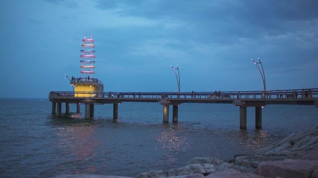 Burlington pier after sunset with people walking along it