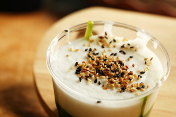 Green coconut sweet pudding in plastic cup scene.