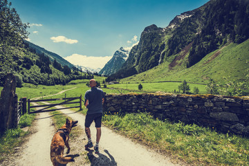 Active man with dog walking in Austria Alps