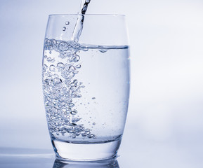 Wasserglas mit frischem Wasser füllen - Trinken bei warmen Temperaturen