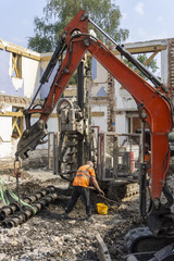 Segmental piling rig and exavator with operators on construction site