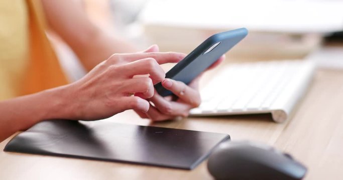 Woman use of mobile phone on working desk