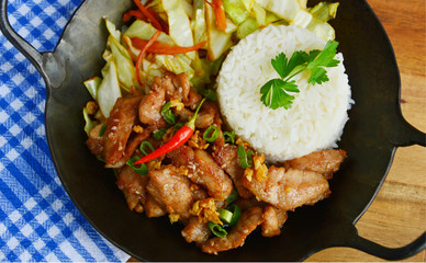 Fried sliced pork with garlic and pepper  served with Fried vegetable and Thai rice in small wok.