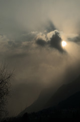 Obraz na płótnie Canvas Sunburst over Rüthi; moody light as the Sun disappears in cloud over the Hoher Kasten