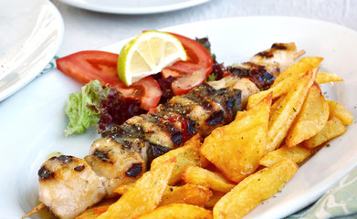 Grilled Greek Chicken with Tzatziki Sauce with French fries and lime. 
