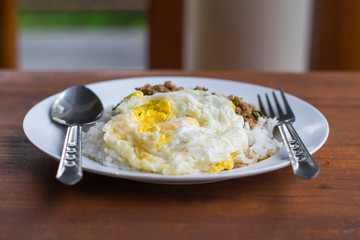 Rice topped with fried egg and stir-fried pork basil