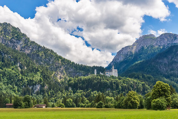 Idyllic landscape in the Alps with green meadows and clouds