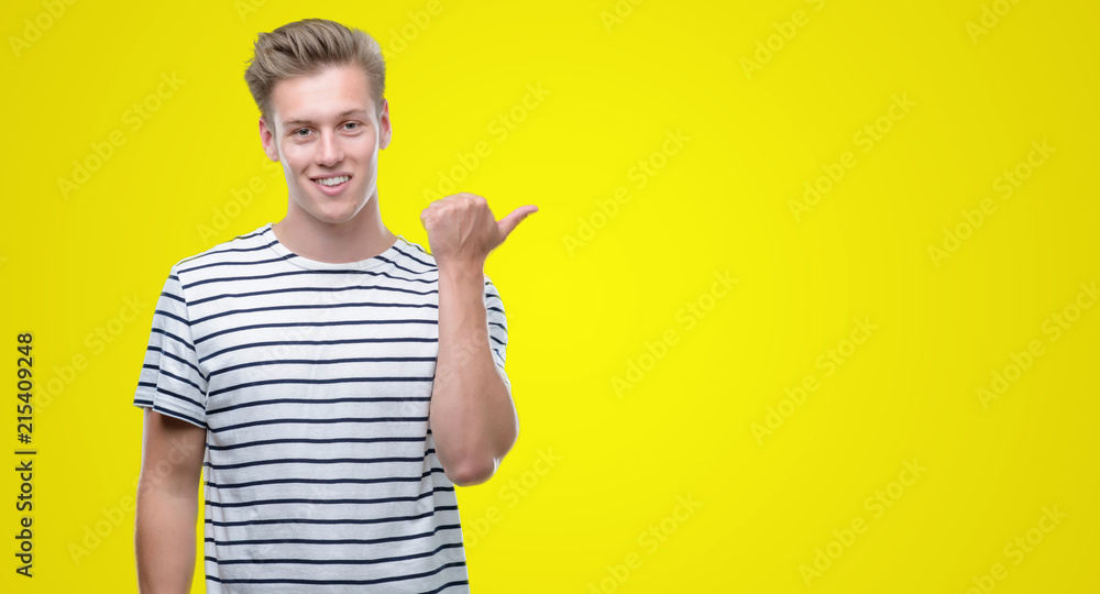 Poster Young handsome blond man wearing stripes sailor t-shirt pointing with hand and finger up with happy face smiling