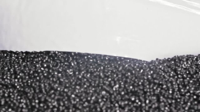 Plastic black gray granulated crumb. Manufacture of plastic water pipes of the factory. Process of making plastic tubes on the machine tool with the use of water and air pressure.