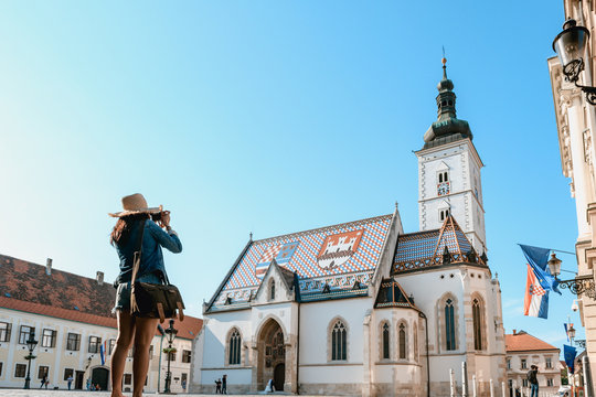 Concept picture of travel in Croatia, women is taking picture St. Mark's Church in Zagreb