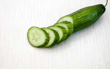Isolated cucumbers. One whole cucumber and slices of cucumber isolated on white background