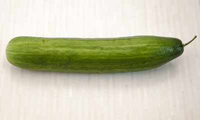 Isolated cucumber. One whole cucumber isolated on table background