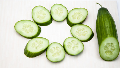 Isolated cucumbers. One whole cucumber and slices of cucumber isolated on white background