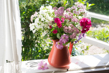Bouquet of garden flowers on windowsill