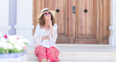 Middle age brunette woman wearing summer hat on vacations serious face thinking about question, very confused idea