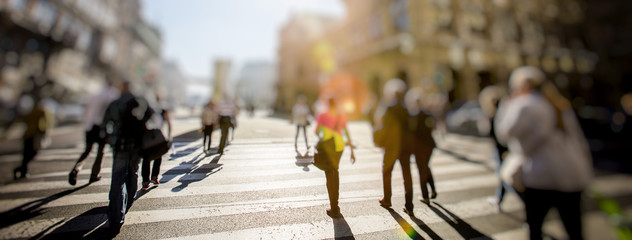 Crowd of anonymous people walking on busy city street