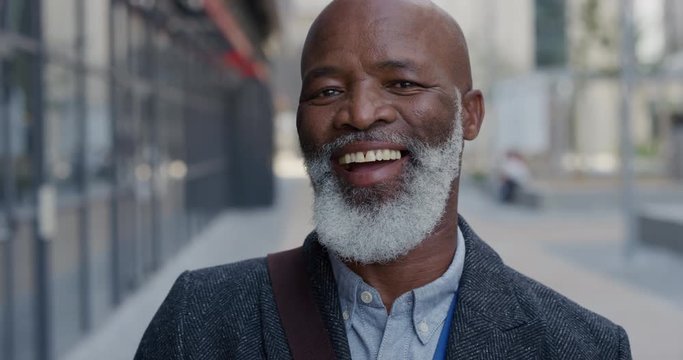 portrait happy senior african american businessman laughing in city enjoying professional urban lifestyle cheerful black man commuter slow motion