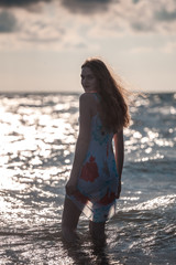 beautiful construction girl in the sea at sunset time